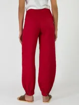 Pantalón de lino color rojo, de corte holgado con botamangas elastizadas y diseño cruzado en la cintura con lazo ajustable.