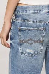 Jeans de tiro medio con diseño wide leg, lavado japan blue con roturas estratégicas y desgastes localizados.