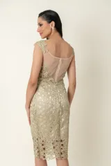 Vestido dorado de cruni con escote y espalda de tul transparente.