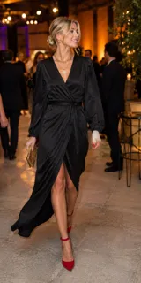 Vestido largo de satén con escote cruzado en V, mangas largas con puños ajustados y falda con abertura frontal. Incluye un lazo para anudar en la cintura.