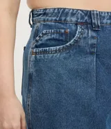 Short de jean azul de tiro alto, con pliegues delanteros y ruedo largo.