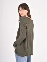 Remera de manga larga color verde oliva, con cuello en V y diseño holgado con caída fluida.