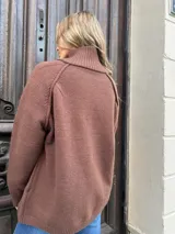 Saco tejido tipo campera color marrón chocolate, con cierre frontal completo, cuello redondo y puños acanalados. Presenta un diseño de corte recto y holgado.