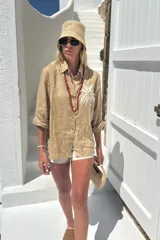 Camisa blanca de lino con bordado de pulpo azul en el pecho, de corte recto y manga larga.