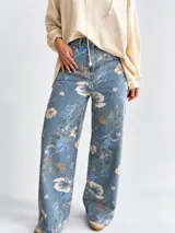 Jean wide leg de tiro alto con estampado de flores y hojas verdes, de corte amplio y cómodo.
