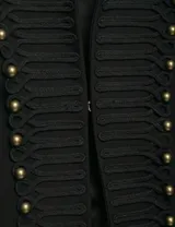 Chaqueta estilo militar color negro, con cuello mao y cierre frontal decorado con cordones trenzados y botones metálicos dorados.