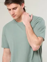 Remera blanca de algodón con cuello redondo y logo bordado de un pájaro en el pecho.