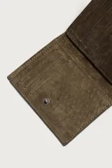 Cartera vertical para hombre fabricada en piel con acabado de serraje, en color verde militar. Dispone de un compartimento principal para billetes, seis posiciones internas para tarjetas y un compartimento para monedas con cierre de cremallera.