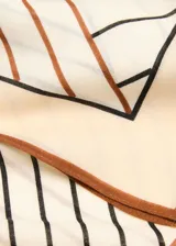 Fular cuadrado de lana con estampado geométrico en tonos beige, marrón y negro, con bordes definidos.