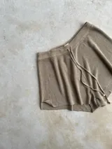 Short de tiro alto color beige, tejido de punto con lurex y cordones ajustables en la cintura.