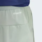 Short deportivo gris con logo Adidas estampado en verde.
