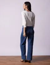 Cardigan tejido en hilado fino color blanco, marca Cable & Gauge. Abertura central con broche interno y terminación ondulada.