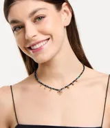 Collar corto con abalorios de cristal en tonos azul y negro, con colgantes metálicos dorados y un dije central de ojo turco.