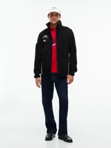 Campera de tejido polar negra Tommy Hilfiger, con cuello chimenea y cierre de cremallera. Presenta diseño Global Stripe en los laterales, bolsillos abiertos en diagonal y el logo de la marca junto con el de Cadillac Formula 1 Team en el pecho.
