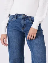 Jean recto de mujer, color azul claro, con pretina con pasadores, botón y cierre. Cuenta con bolsillos delanteros y traseros, y costura lateral asimétrica.