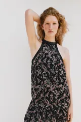 Top halter de tejido estampado con hilo metalizado y lentejuelas, cuello alto y bajo asimétrico con forro interior y cierre trasero con botones.