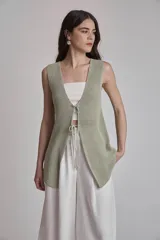 Chaleco largo de punto color verde claro, sin mangas, con escote en V y cierre frontal de lazo.