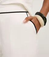 Short blanco de viscolino con cintura elástica y ribetes (bies) contrastantes negros en el borde.