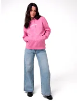 Buzo tipo canguro color rosa, con capucha ajustable mediante cordones, bolsillo frontal y logo de la marca Caterpillar bordado en el pecho en color blanco. Presenta puños y cintura de punto acanalado.