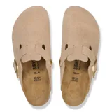 Zuecos Birkenstock modelo Boston Leve en color beige arena, confeccionados en gamuza, con una tira ajustable con hebilla metálica en el empeine y suela de goma negra.