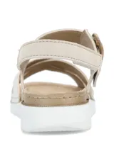 Sandalias planas de mujer en color beige, con tiras cruzadas en el empeine, una de ellas con textura plateada brilhante. Cuenta con tira ajustable al tobillo mediante hebilla con efecto carey y suela blanca con base dentada.