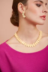 Conjunto de collar corto y aros dorados con diseño de hojas texturizadas. El collar es tipo choker y los aros son colgantes.