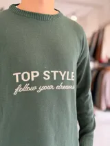 Sweater de punto color beige con cuello redondo, manga larga y diseño estampado en el pecho con las frases "TOP STYLE" y "follow your dreams" en color marrón.