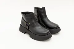 Borcego de cuero negro con aplique de estribo y suela track.