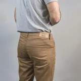 Pantalón de gabardina color marrón claro, corte slim fit y diseño clásico de cinco bolsillos.