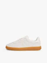 Zapatillas de corte bajo Tommy Hilfiger de inspiración retro, confeccionadas en ante color blanco con suela de goma color caramelo. Presentan monograma TH tonal en el lateral, detalles de ventilación en la puntera y cierre con cordones.