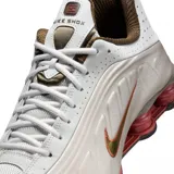 Championes Nike Shox R4, color negro y plateado, con diseño aerodinámico y sistema de amortiguación de columnas Shox en el talón.