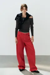 Jeans estilo baggy oversize de tiro medio en color rojo, con cinco bolsillos, trabillas para cinto y costuras decorativas marcadas en las piernas.