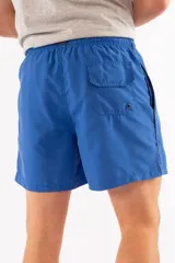 Short de baño azul con cintura elástica y cordón ajustable. Tiene dos bolsillos laterales y un bolsillo trasero.