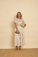 Pollera midi de algodón con estampado floral en tonos pasteles, diseño cruzado con pinzas y elástico en la parte posterior de la cintura.