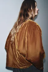 Kimono abierto de terciopelo color marrón, con diseño acolchado y bordados florales en hilo dorado en el frente. Presenta mangas largas y costuras decorativas a contraste.