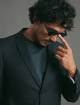 Saco sport de corte clásico, con cuello de solapa, cierre frontal de dos botones y bolsillos de ribete laterales.