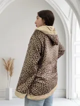 Campera marrón con estampado animal print, capucha y cierre con botones.