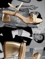 Sandalias de tacón bajo color blanco, con tiras finas y cierre con hebilla.