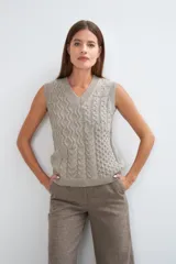 Chaleco de lana color crudo, tejido con escote en V y diseño con diferentes puntos combinados en el frente.