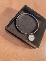 Pulsera rígida de plata 925 con dije redondo grabado.