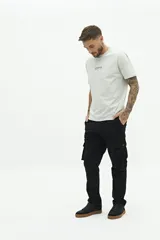 Remera de manga corta color beige con estampado gráfico en la espalda que representa el edificio Chrysler de Nueva York y texto descriptivo.