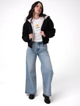 Chaqueta negra de lona con forro interior de sherpa, cierre frontal con cremallera, capucha ajustable con cordón y puños y bajo de punto acanalado.