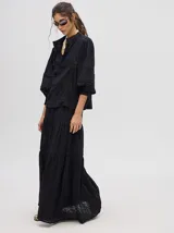 Camisa de broderie de algodón color negro, con diseño de calados, cuello mao con cierre de botones, mangas abullonadas con puños fruncidos y detalles de galones con transparencias.