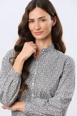 Camisa de algodón celeste con estampado floral pequeño, cuello mao, mangas largas con puños fruncidos y cierre frontal de botones.