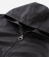 Chaqueta masculina de poliuretano color negro, con diseño de capucha, cierre frontal completo y puños elásticos. Presenta un acabado liso y estructura robusta.