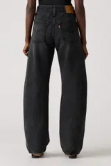Pantalón de jean de corte baggy con diseño barrel, de tiro medio y color negro lavado. Presenta costuras laterales curvas que acentúan su silueta amplia y estructurada.