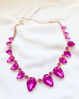 Gargantilla dorada con strass fucsia en forma de gota.