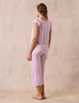 Conjunto de pijama marca René Rofé, compuesto por una remera de escote en V con botones y un pantalón capri con cintura elastizada, ambos en tejido soft estampado con motivos florales en tonos celeste y blanco.