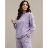 Pijama de dos piezas de tejido plush texturado con diseño de puntos en relieve, compuesto por un buzo de manga larga con cuello redondo y un pantalón largo de corte recto.