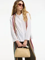 Camisa blanca de corte holgado con cuello camisero y cierre frontal de botones. Confeccionada en algodón, presenta un diseño clásico y versátil.